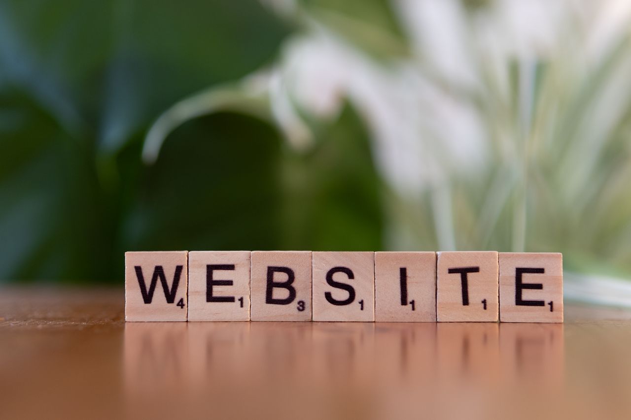 Services Scrabble tiles on a wooden surface forming the word 'Website', symbolizing digital communication.
