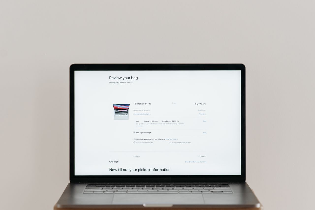 Home Minimalist laptop showing an online checkout screen on a white background, ideal for tech context.